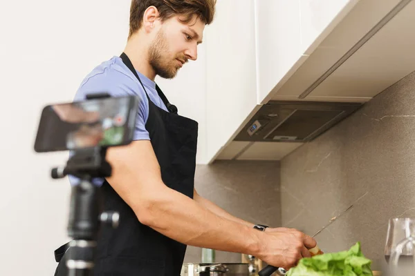 Joven Bloguero Barbudo Chef Está Pelando Cebollas Con Cuchillo Una —  Fotos de Stock
