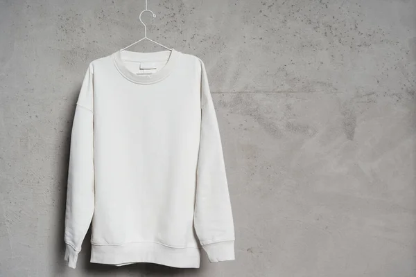 Attrappe Eines Weißen Sweatshirts Das Einem Dünnen Metallbügel Einer Betonwand — Stockfoto