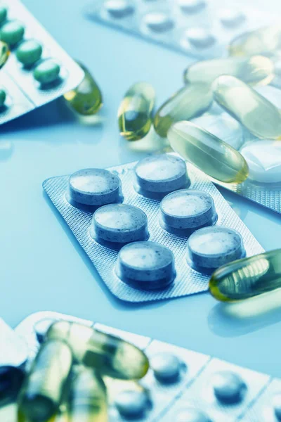 Zbliżenie Różnych Tabletek Kapsułek Niebieskim Świetle Medycznym — Zdjęcie stockowe