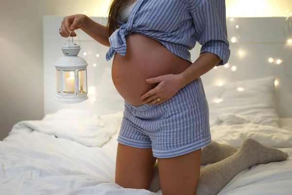 年轻而性感的孕妇 舒适的卧室里挂着烛光灯笼 — 图库照片