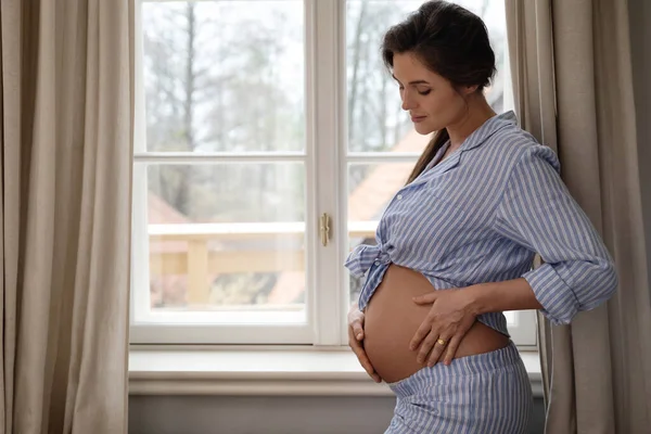 Młoda Zmysłowa Kobieta Ciąży Stojąca Przy Oknie Domu — Zdjęcie stockowe