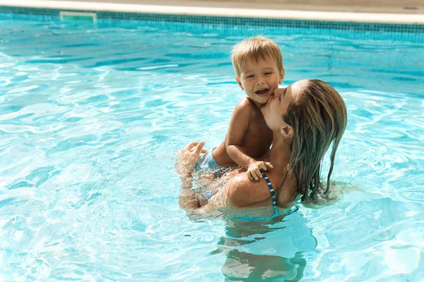暑假期间 快乐的妈妈和她可爱的小儿子在室外游泳池游泳 — 图库照片
