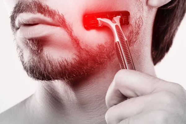 用安全剃须刀刮胡子时皮肤敏感的男人 — 图库照片