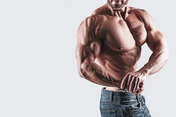 Musculaire Man Bodybuilder Dragen Jeans Poseren Tegen Grijze Achtergrond — Stockfoto