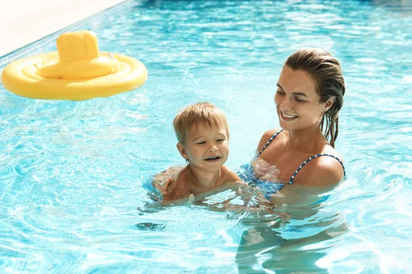 暑假期间 快乐的妈妈和她可爱的小儿子在室外游泳池游泳 — 图库照片