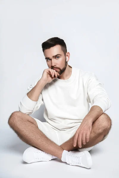Handsome Man Wearing White Sweatshirt Shorts Wireless Earbuds Sitting Gray — Stock Photo, Image
