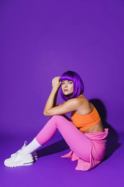 Portrait Young Woman Wearing Colorful Sportswear Sitting Purple Background — Stock Photo, Image