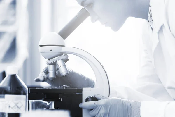 Vrouwelijke Wetenschapper Gebruikt Microscoop Een Laboratorium Tijdens Onderzoek Getint Blauwe — Stockfoto