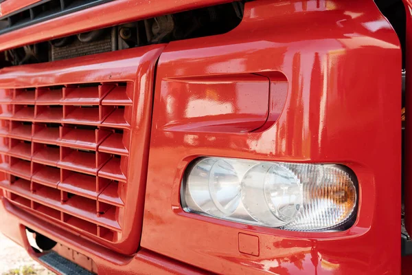 Zbliżenie Przedniej Części Czerwonej Ciężarówki Kratą Chłodnicy Reflektorem — Zdjęcie stockowe