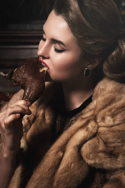 Imagen Provocativa Hermosa Mujer Con Abrigo Piel Comer Pierna Pollo — Foto de Stock