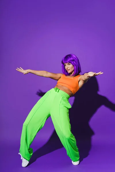 Активная Танцовщица Яркой Спортивной Одежде Выступающая Фиолетовом Фоне — стоковое фото