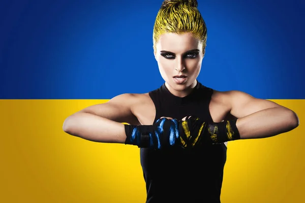 背景上挂着乌克兰国旗的强势女战士的创造性形象 — 图库照片