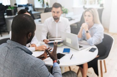 Modern ofiste yapılan toplantıda bir grup çok ırklı iş adamı