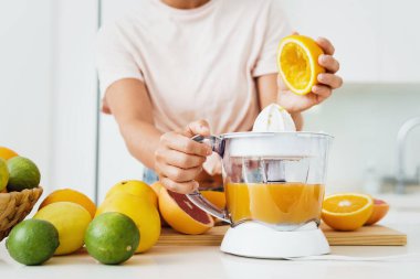 Taze portakal suyu hazırlama sırasında kadın eli ve narenciye yakın çekim.