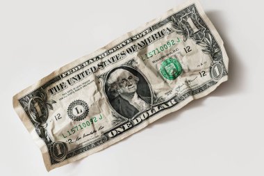 Closeup shot of a crumpled worn out one dollar bill. Concept of financial crisis and poverty. clipart