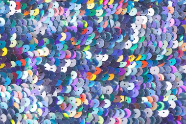 Closeup shot of a shiny multicolored sequin fabric made of linked colorful metallic circles. clipart