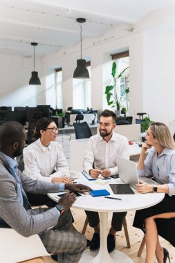 Modern ofiste yapılan toplantıda bir grup çok ırklı iş adamı