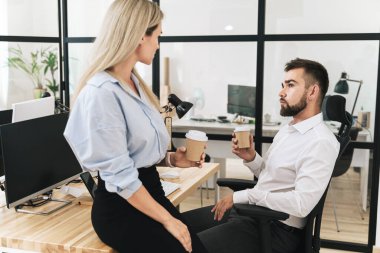 Modern ofiste kahve molası sırasında kendine güvenen genç iş adamları.