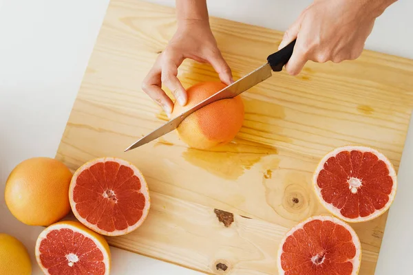 若いです女性カットグレープフルーツ上の切断ボードのために自家製フレッシュジュース — ストック写真