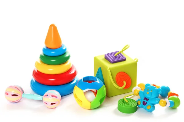 カラフルなプラスチック製のおもちゃやパズルの足の小さな子供たちのコレクションの閉鎖ショット 白い背景に論理と細かいモータースキルの開発のために良い — ストック写真