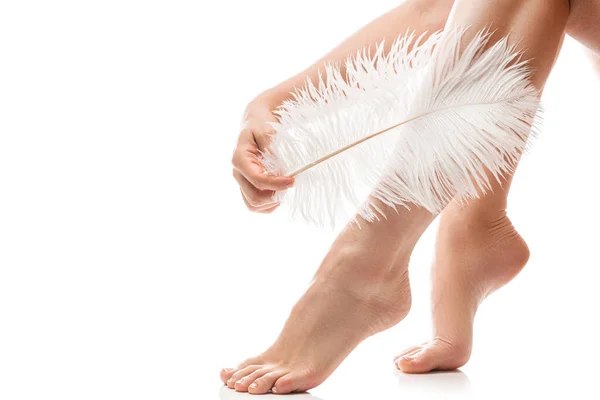 白い背景に滑らかな肌と柔らかいダチョウの羽を持つ女性の足の閉鎖 — ストック写真