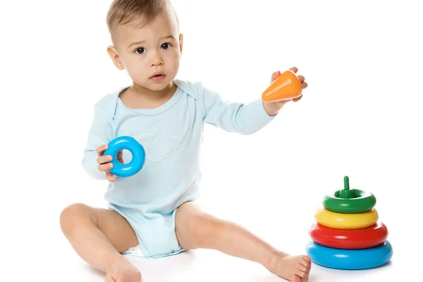 Küçük Sevimli Bir Çocuk Beyaz Arka Planda Plastik Oyuncakla Oturuyor — Stok fotoğraf