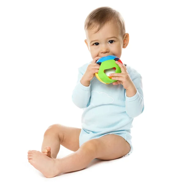 穿着保险杠的可爱的小男孩坐在那里玩着塑料玩具 把它放在他的嘴上 放在白色的背景上 — 图库照片