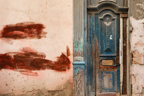 壁が割れた古い建物の中のみすぼらしい木製のドア — ストック写真