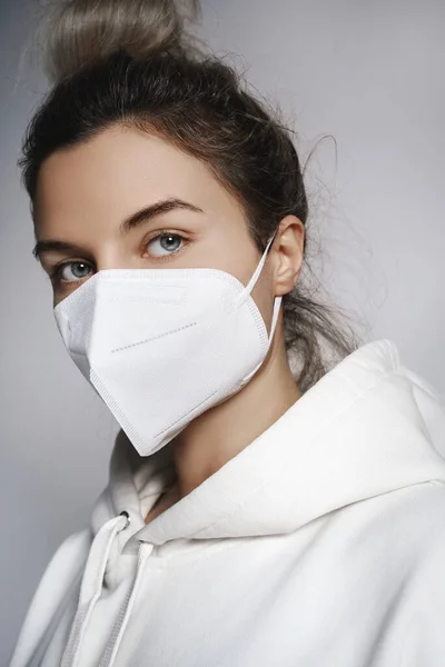 Jonge Vrouw Draagt Witte Hoodie Ffp2 Masker Tegen Grijze Achtergrond — Stockfoto