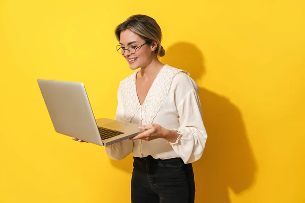 Cheerful Young Woman Wearing Eyeglasses Using Laptop Computer Yellow Background — Stock Photo, Image