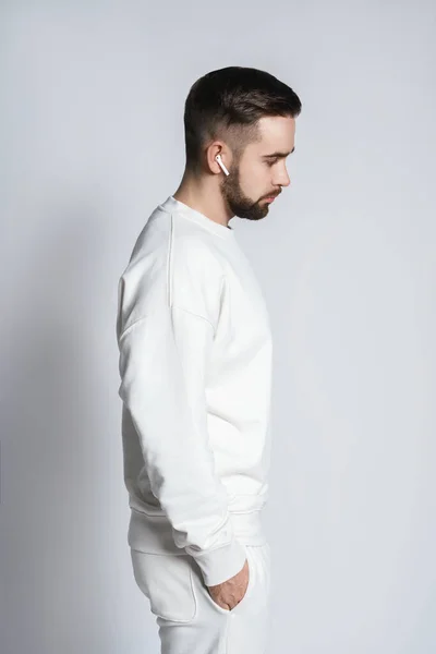 Schöner Mann Weißem Sweatshirt Mit Drahtlosen Ohrhörern Vor Grauem Hintergrund — Stockfoto