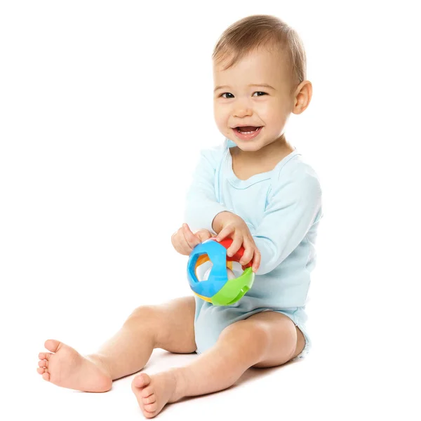 一个可爱的坐在保险杠里笑着的小男孩坐在那里 拿着白色背景的塑料玩具玩耍 — 图库照片
