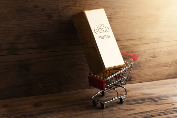 Closeup Shot Large Shiny Gold Bar Put Tiny Shopping Cart — Stock Photo, Image