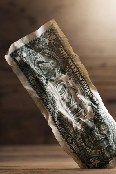 一张皱巴巴的一块钱钞票卡在地板缝隙里的特写镜头 — 图库照片