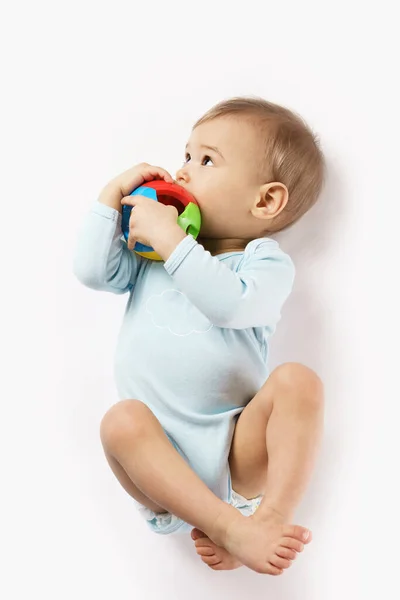 Чарівний Маленький Хлопчик Романі Лежить Грається Пластиковою Іграшкою Кладе Рот — стокове фото
