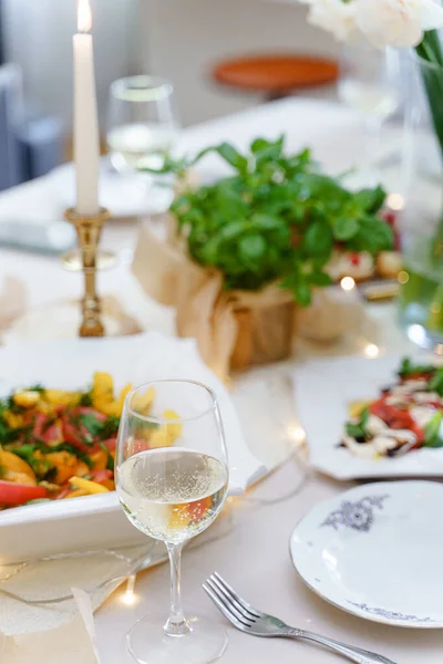 新鮮な食べ物と白ワインと夕食のために提供される祭りのテーブル 花やキャンドルで飾られて — ストック写真