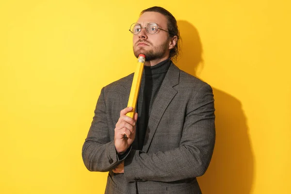 Bearded Man Glasses Holding Big Pencil Thinking Yellow Background — Stock Photo, Image