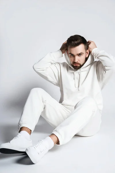 Handsome Man Wearing Blank White Hoodie Pants Sitting Light Gray — Stock Photo, Image