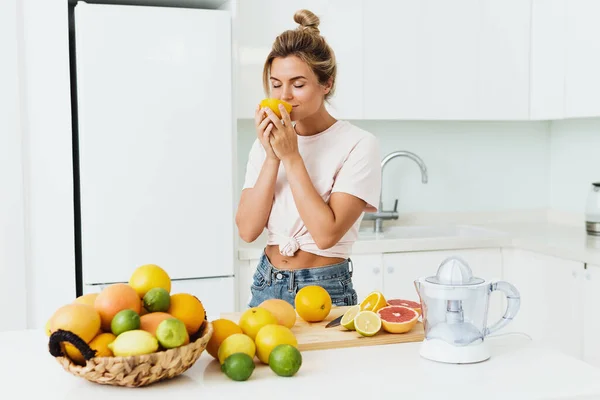 Jonge Mooie Vrouw Snuiven Verse Sinaasappel Tijdens Citrussap Bereiding Thuis — Stockfoto