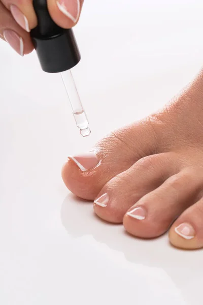 Крупный План Женской Ноги Бутылки Питательного Масла Кутикулы Капельницей Белом — стоковое фото
