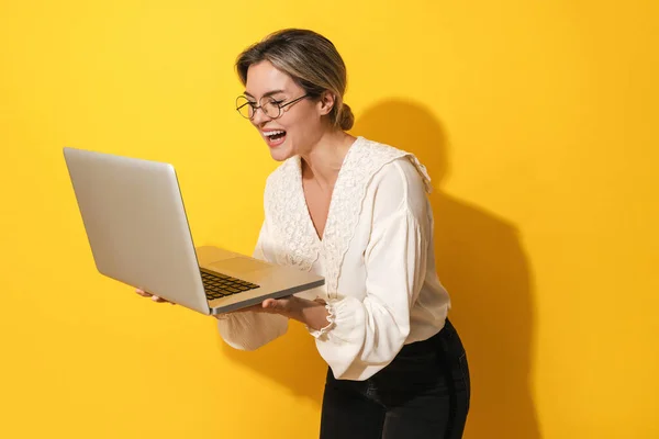 Cheerful Young Woman Wearing Eyeglasses Using Laptop Computer Yellow Background — Stock Photo, Image
