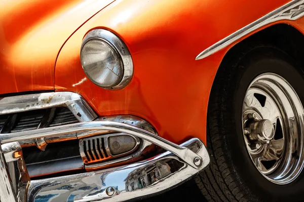 停在街上的一辆亮晶晶的老式橙色轿车旁边 — 图库照片