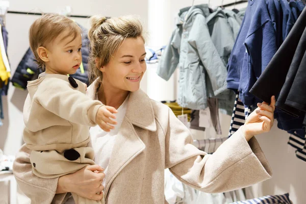 Young Woman Her Baby Son Choosing Clothing Clothes Store — Stock Photo, Image