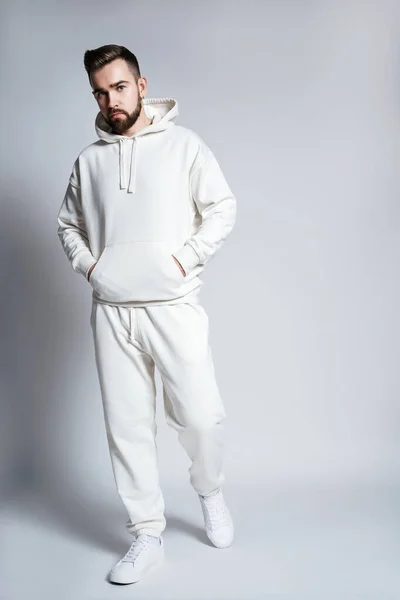 Schöner Mann Mit Weißem Kapuzenpulli Und Hose Posiert Auf Grauem — Stockfoto