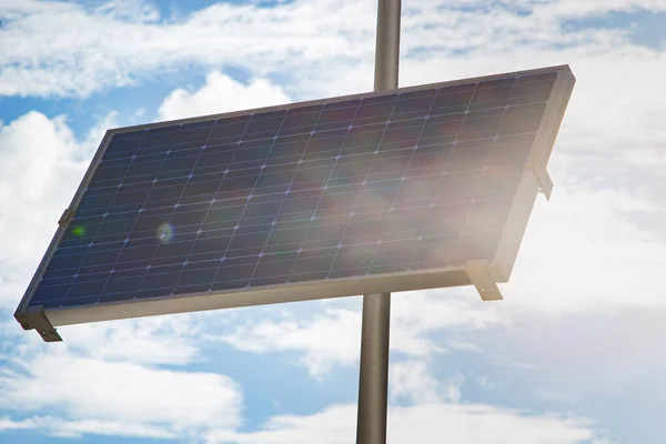 stock image Closeup shot of a black photovoltaic solar panel on a sunny day with cloudy sky background. Concept of a renewable eco friendly energy and modern technology.