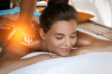 Asya 'daki geleneksel klinikte sırt masajı tedavisi gören genç bir kadın.