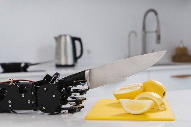 Gerçek robotun eli keskin bıçakla limon kesiyor. Robot işlem otomasyonu kavramı.