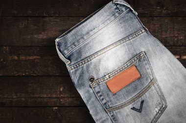 Ahşap arka planda kot pantolonun yakınlaştırılması.