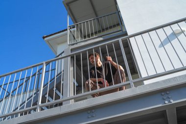 Mahallesindeki apartman kompleksinin yanında duran genç bir adamın alçak açısı.