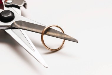 Beyaz arka planda budama ve alyans yakın plan. Düğün iptal ya da boşanma kavramı.